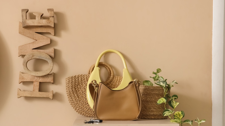 An entryway table cluttered with bags and keys