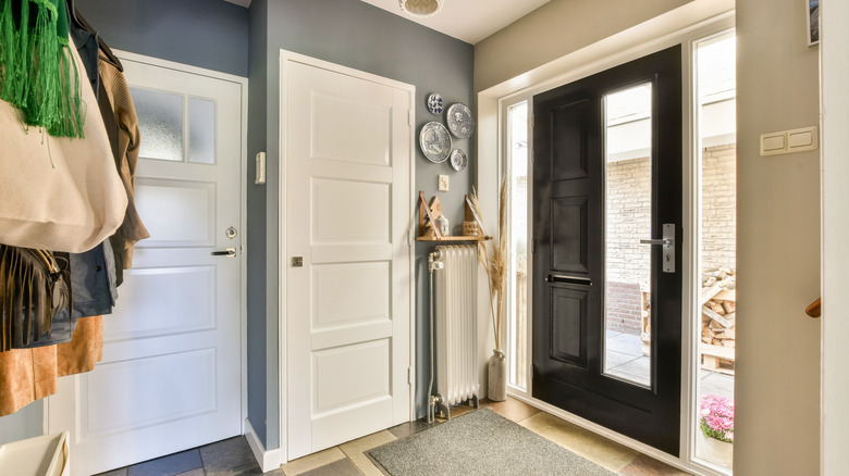 A small blue entryway with decor on the wall and a shelf