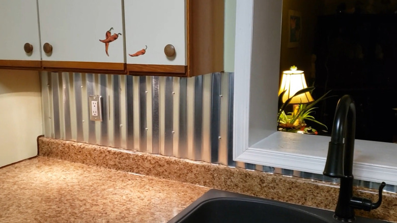 A kitchen counter with a corrugated metal backsplash