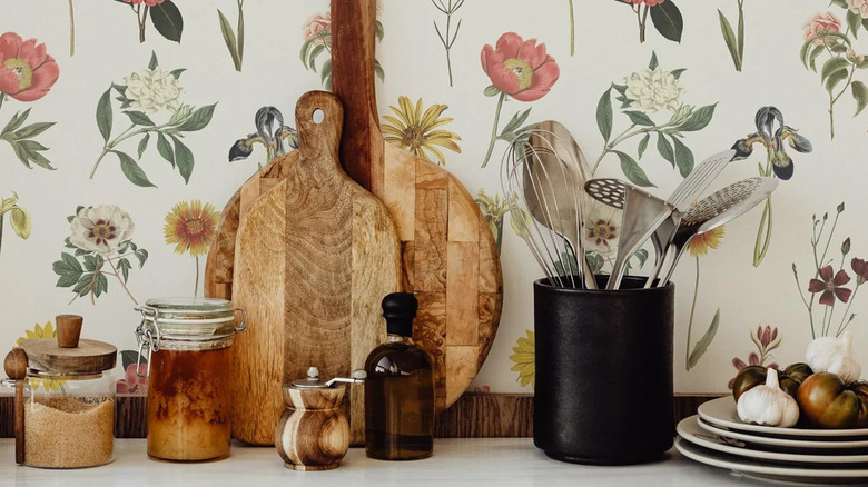 A countertop with a floral wallpaper backsplash