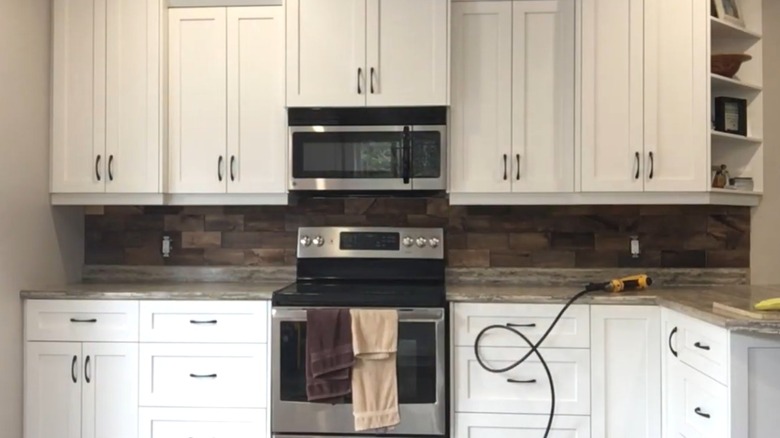 A kitchen with a dark wood backsplash