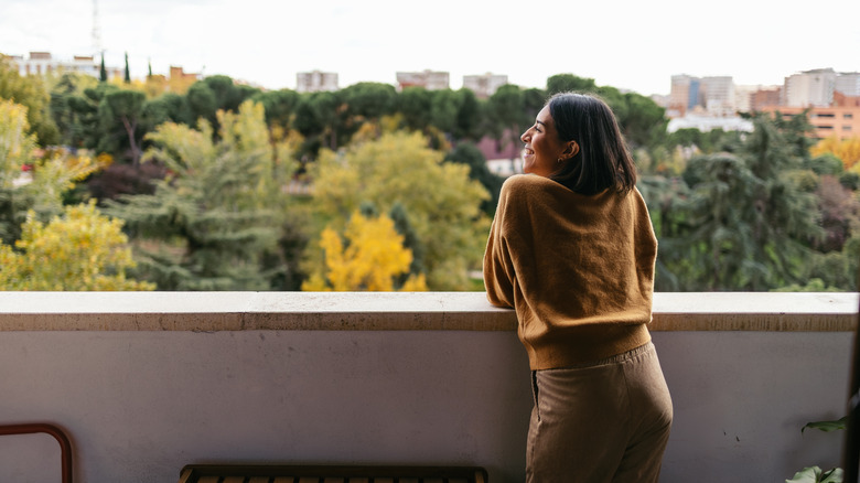 Woman standing on a balcony and looking at the city view