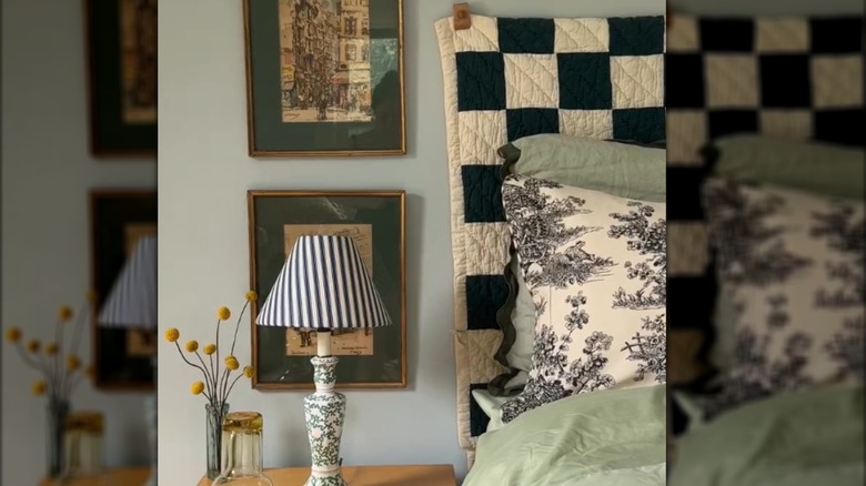Bed with black and white checkered quilt beside vintage-style bedroom furniture
