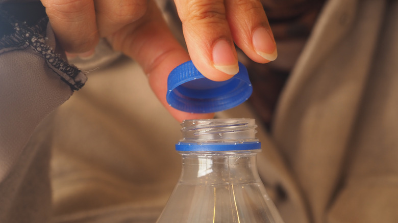 A person removes a bottle cap