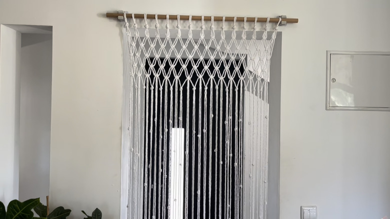 DIY macrame curtain turned room divider using curtain rod hardware