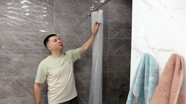 Person pulling on a shower curtain
