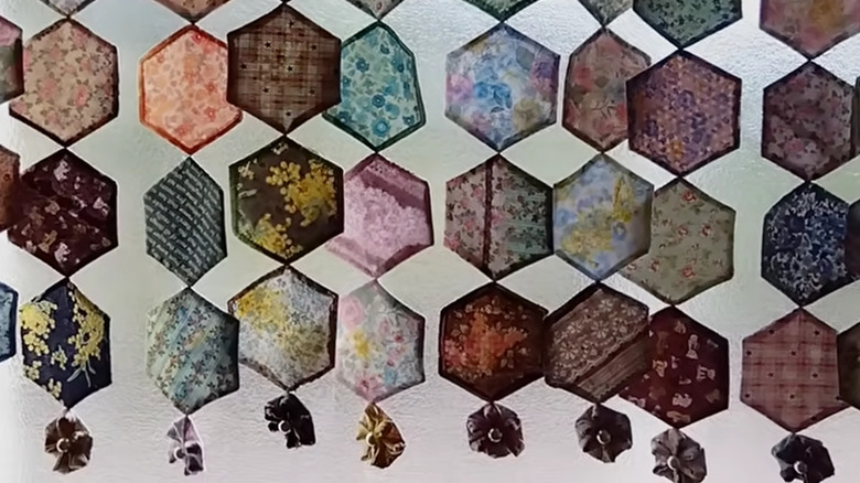 Pendant-style scrap fabric window covering made of hexagons sewn together.