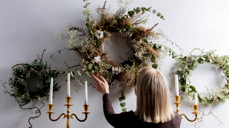 Woman taking wreaths off wall