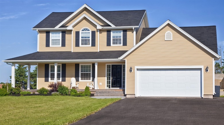 Two-story house with beige vinyl siding and white trim