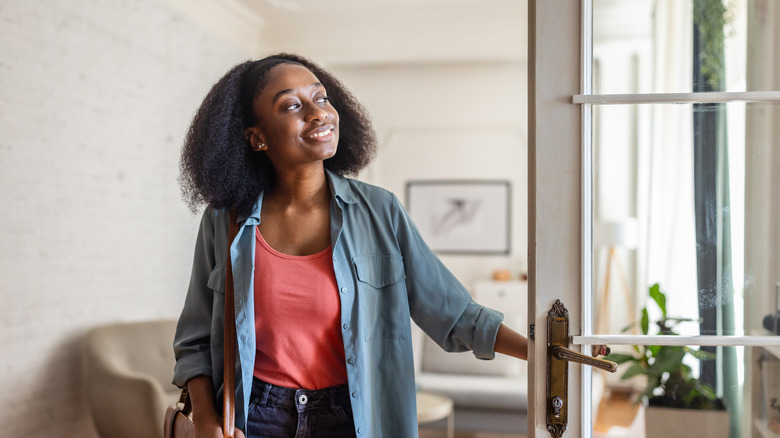 Woman opens front door and smiles