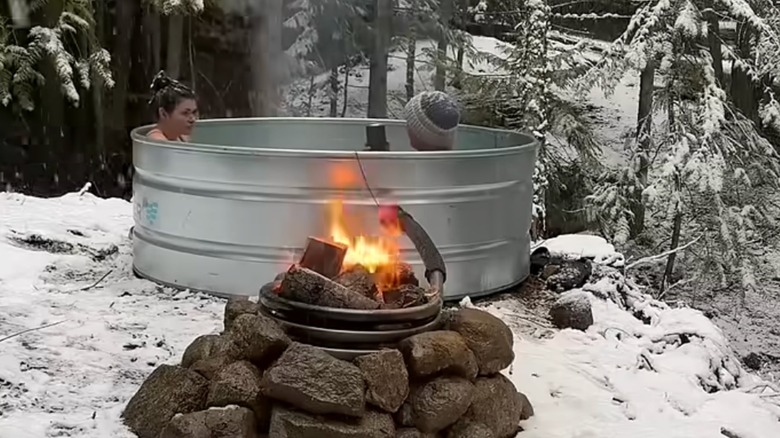 Two people soaking in a DIY stock tank hot tub