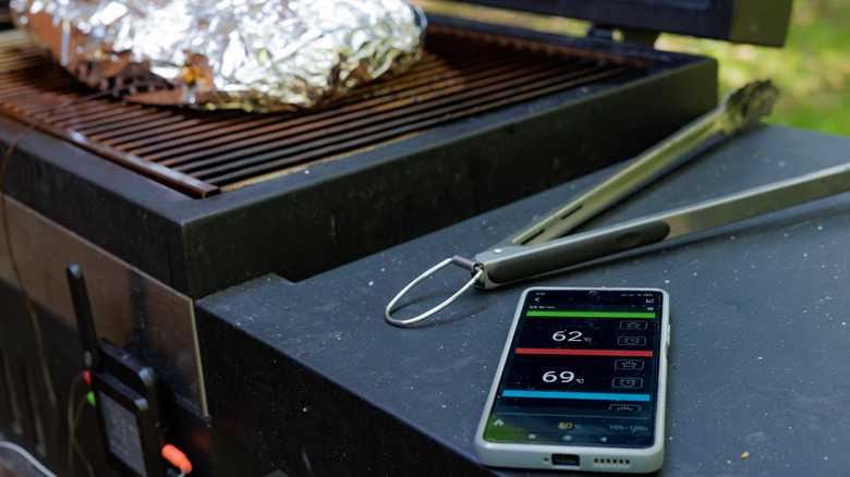 Brisket on a grill by a smartphone