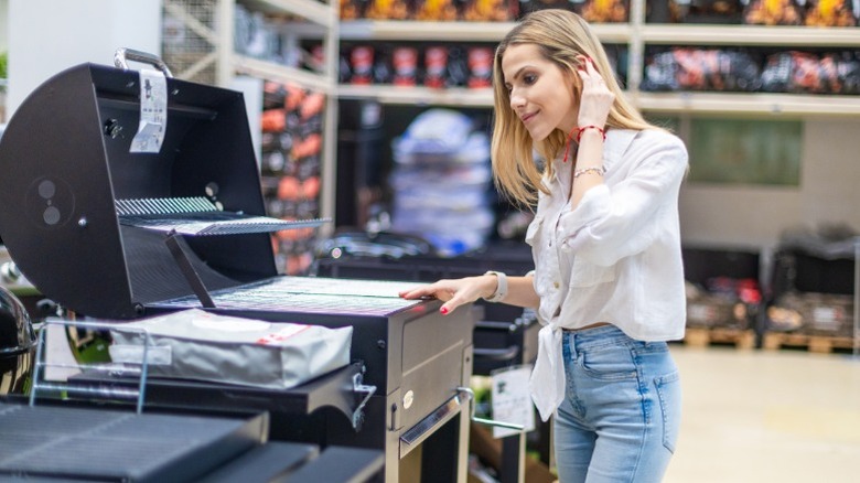 Woman shopping for grills in a retail store