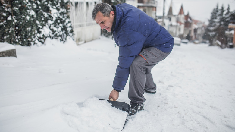 man clearing snow with shovel