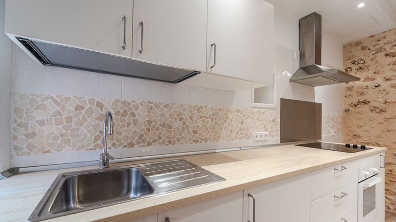 Natural stone mixed with white tile backsplash