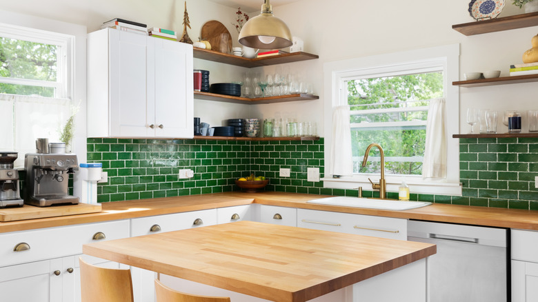 Kitchen with green tile backsplash and wood countertops