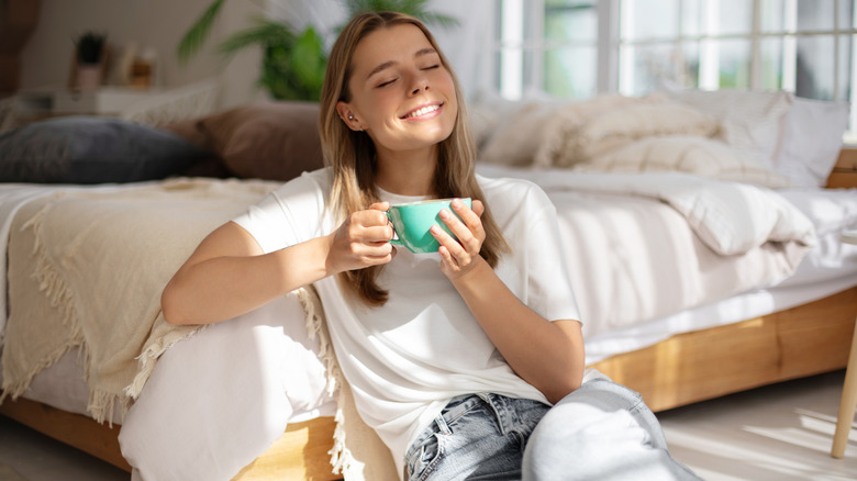 A woman sitting in a bedroom smiling