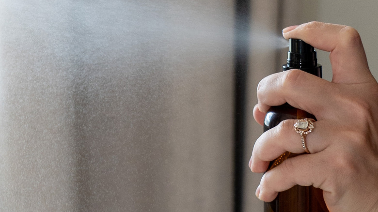 Someone spraying a solution onto their curtains