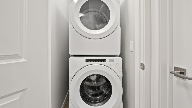 stacked white washer and dryer set in small space