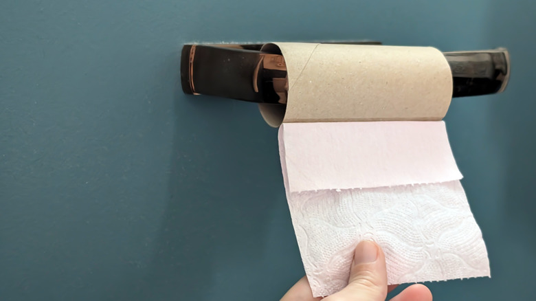 Hang pulling the last sheet off of a toilet paper roll