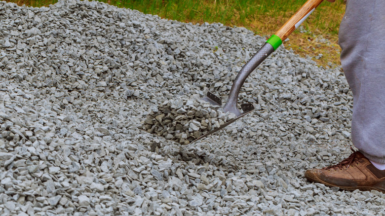 Person spreading gravel with a shovel