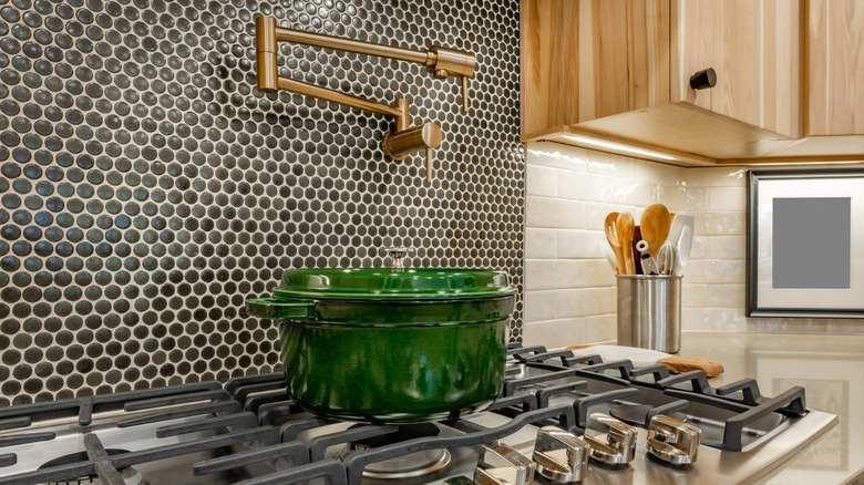 a kitchen with a black penny tile backsplash