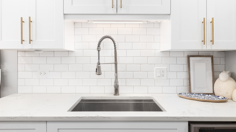 a kitchen with a white subway tile backsplash