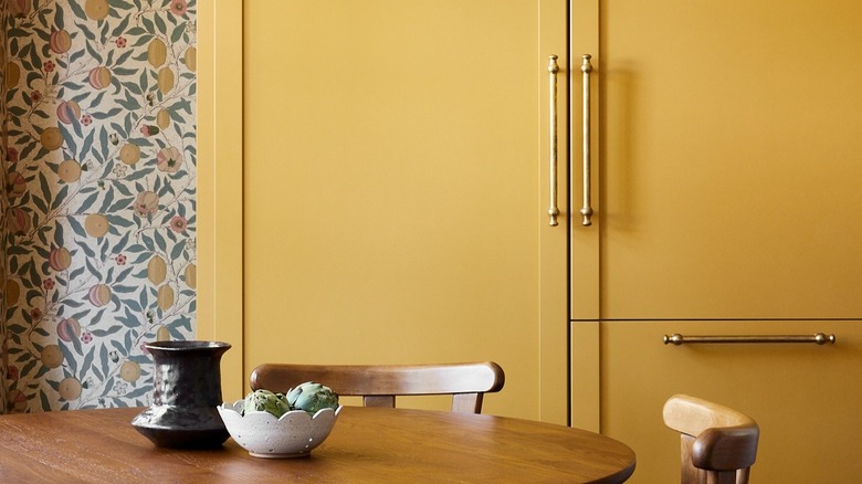 A large freestanding kitchen cabinet is painted Farrow & Ball India Yellow