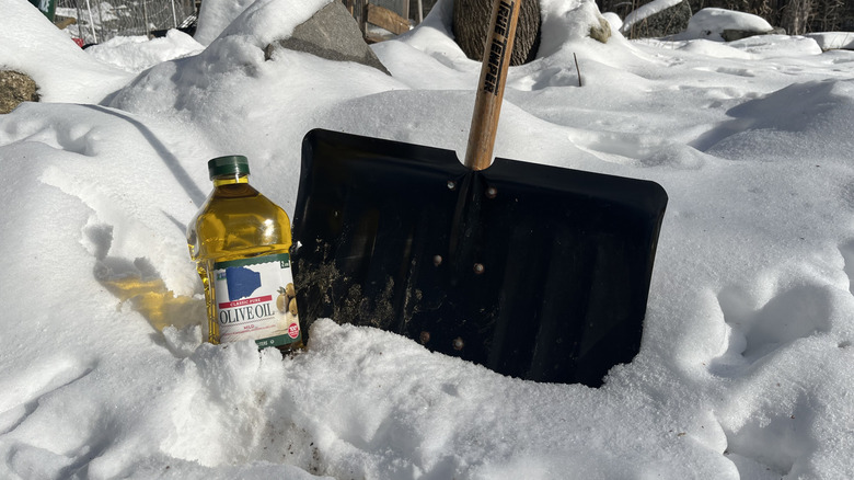 Shovel and olive oil in a big snow pile