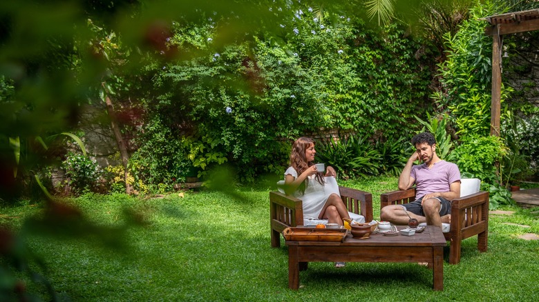 Young couple relaxing in chairs outside on the lawn