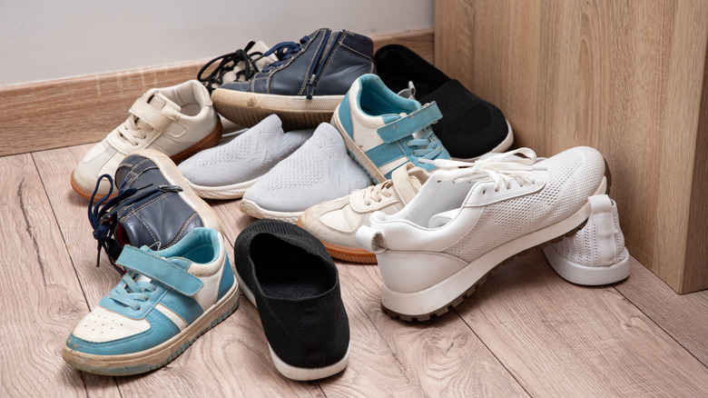 Collection of dirty shoes piled up on the floor