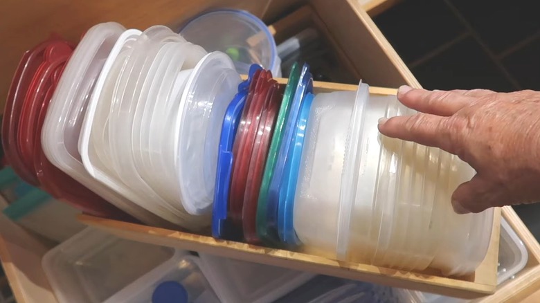 Person reaching for collection of food container lids