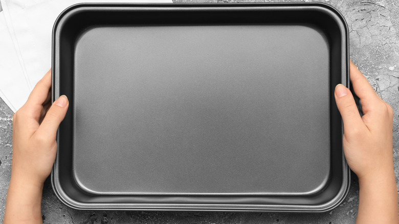 Woman with hands on a baking sheet