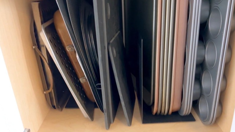 Cabinet filled with vertical bakeware after organizing trick