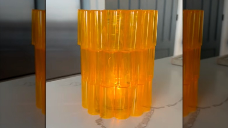 Eclectic DIY table light with orange bottle exterior on white stone countertop