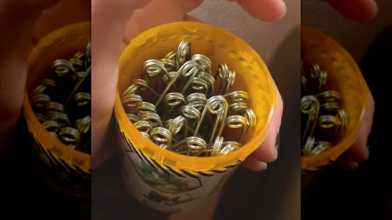 Decorated pill bottle filled with metal safety pins