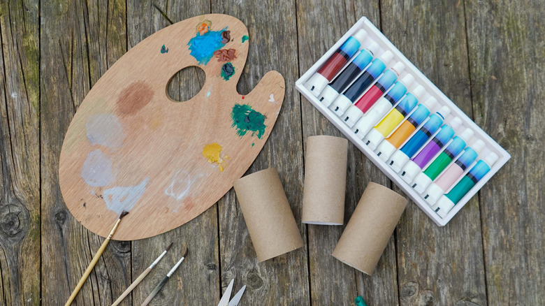 Toilet paper tubes next to painting supplies