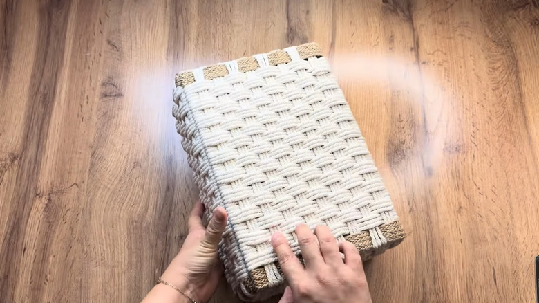 A shoebox covered in woven string made to look like a basket