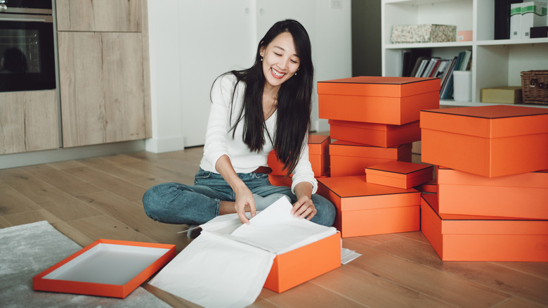 A woman opens up an orange shoebox