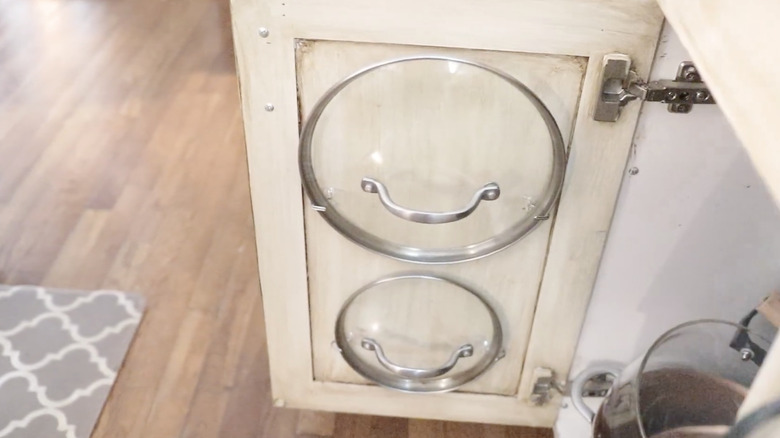 Pot lids store on the back of a cabinet door