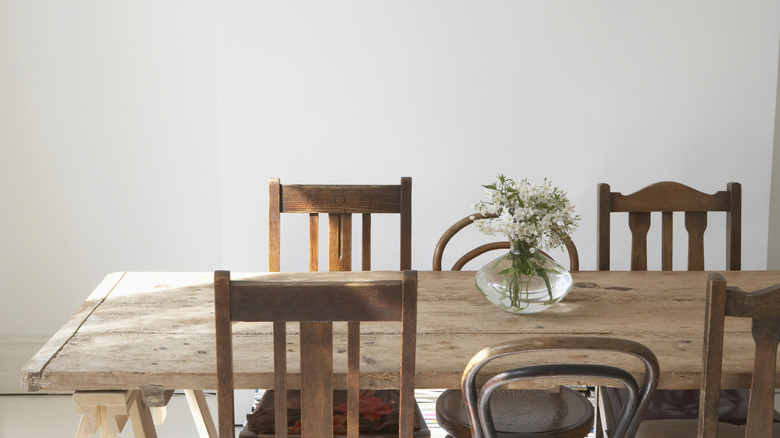 Dining table made from recycled wood with vase of wildflowers