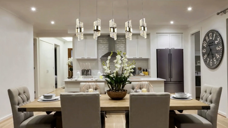 Modern dining room and kitchen combo with artistic lights over the table