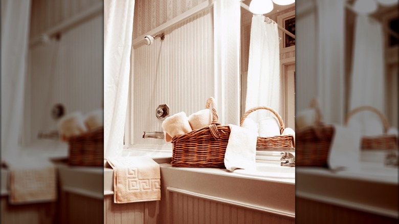 Wicker basket on a bathroom countertop with towels in it