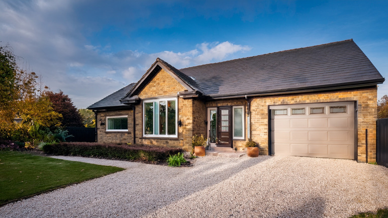 A suburban home with gravel driveway.