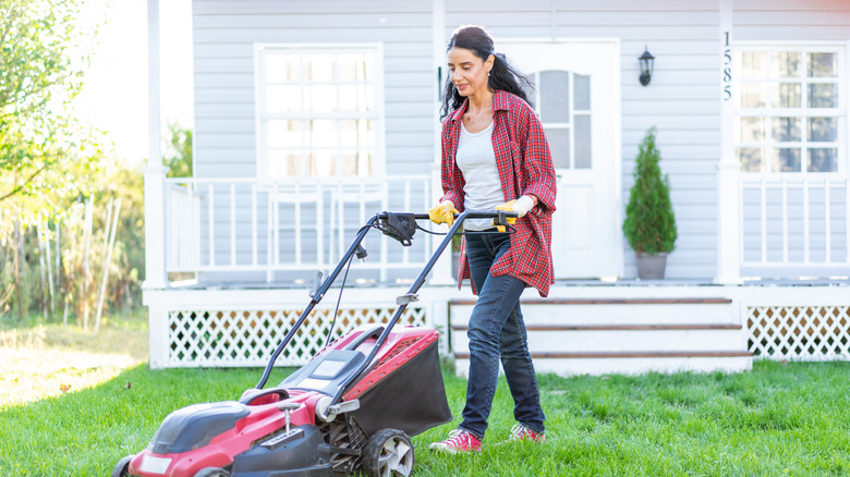 Woman mowing a lawn