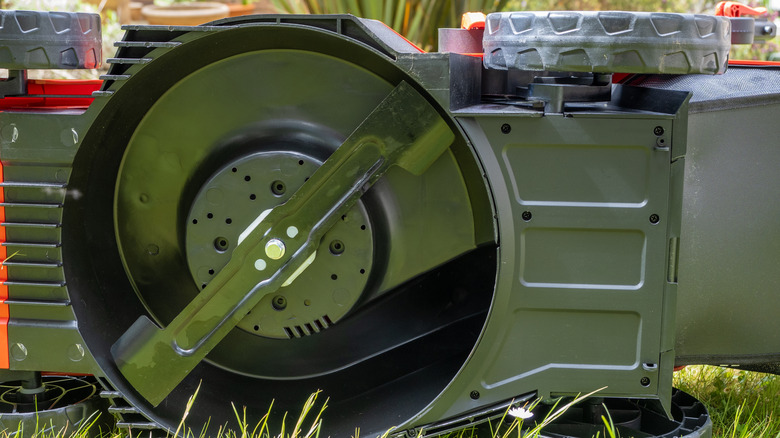 Lawn mower tipped on its side to reveal the blade