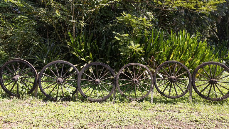 A fence made of rustic iron wagon wheels