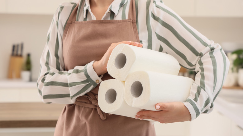 A person carrying a stack of paper towels