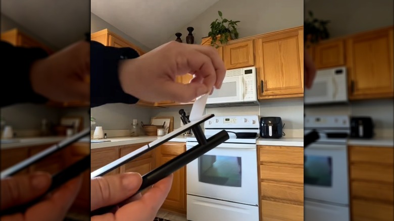 Woman peeling the sticker off a peel-and-stick black handle