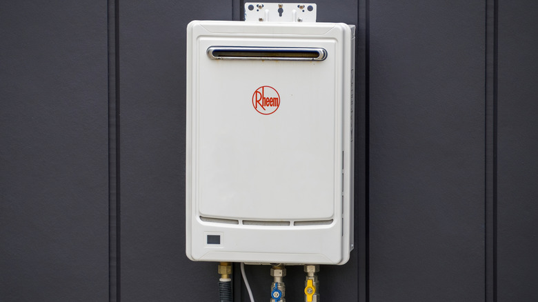 A tankless gas water heater installed on a basement wall